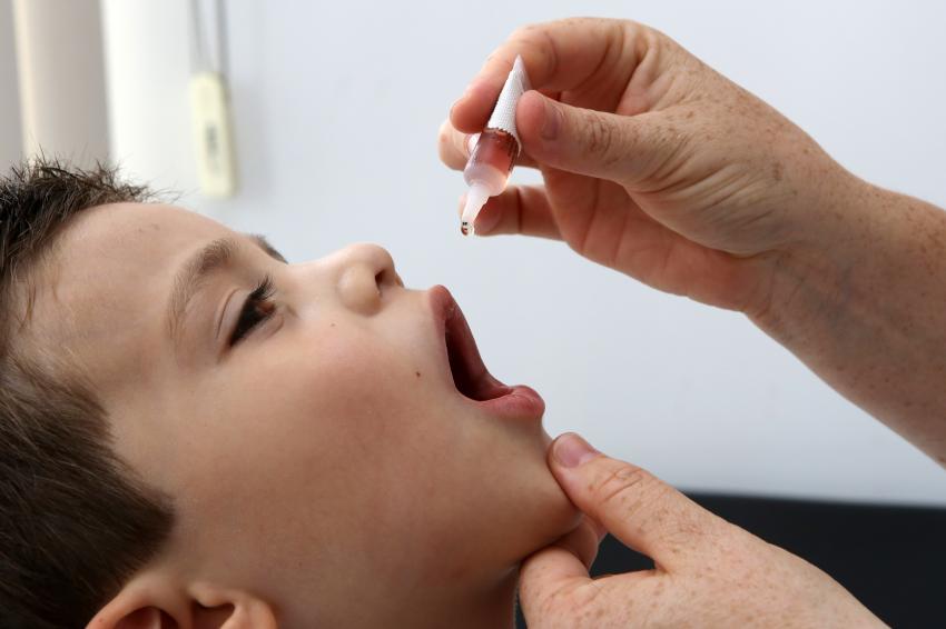 Médico dá vacina para polio para menino