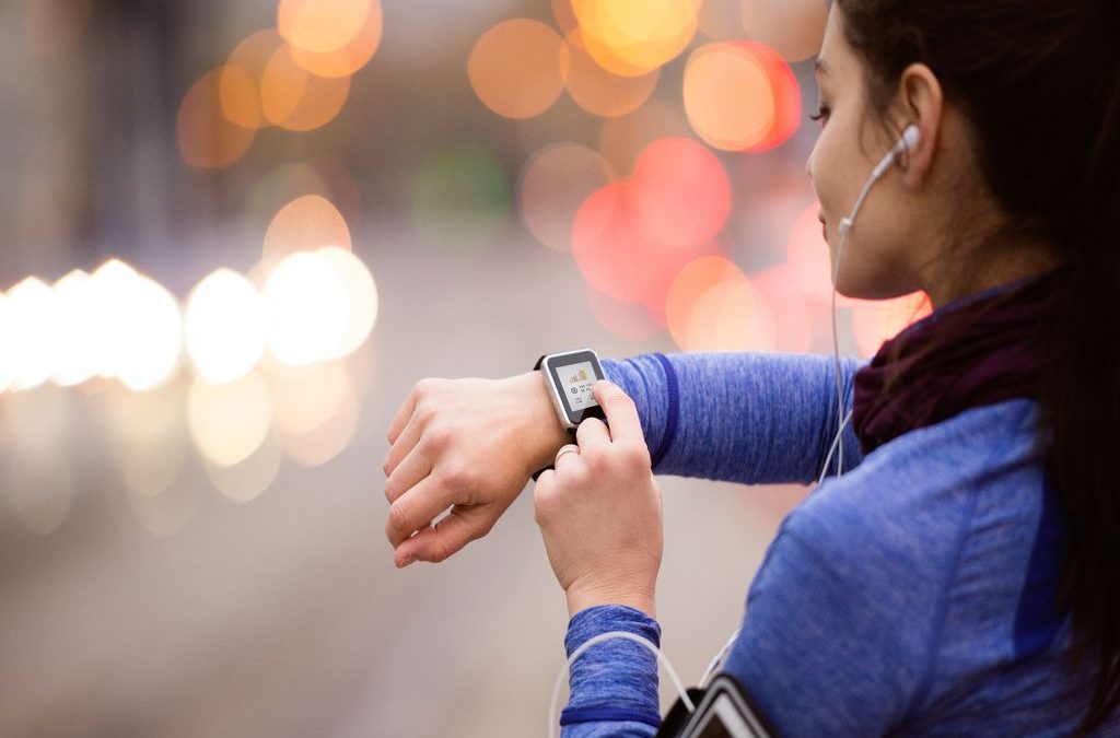 Mulher mexe em smartwatch enquanto escuta música