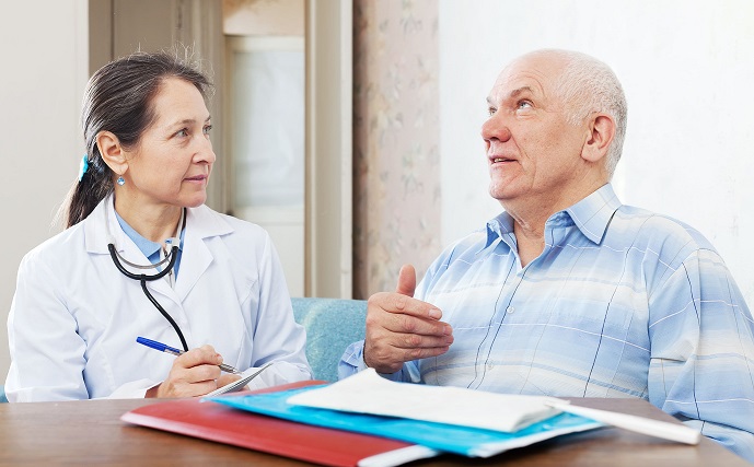 Paciente homem de meia idade conta seus sintomas em consulta médica com doutora