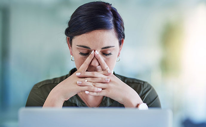 Mulher em meio a incertezas com ansiedade sentada em frente a um computador