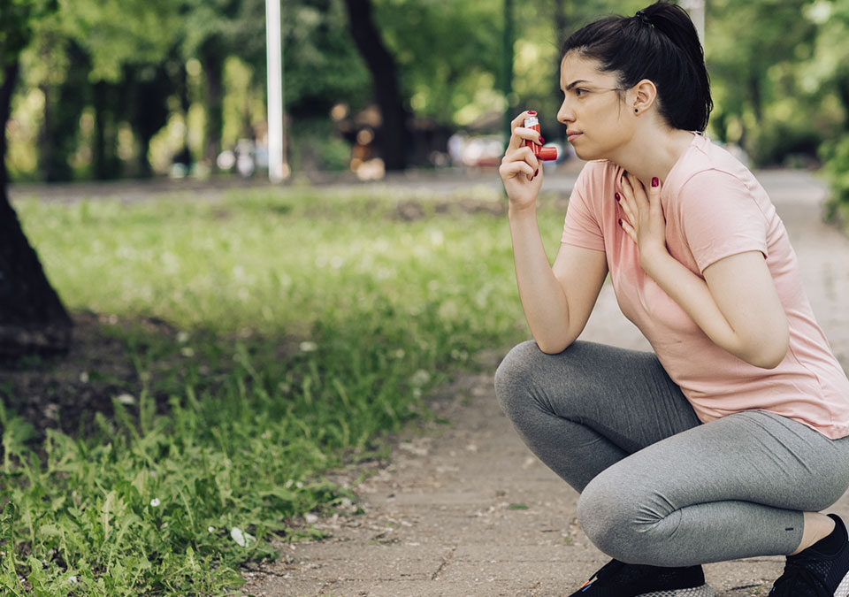 Menina usando inalador de asma durante corrida em parque