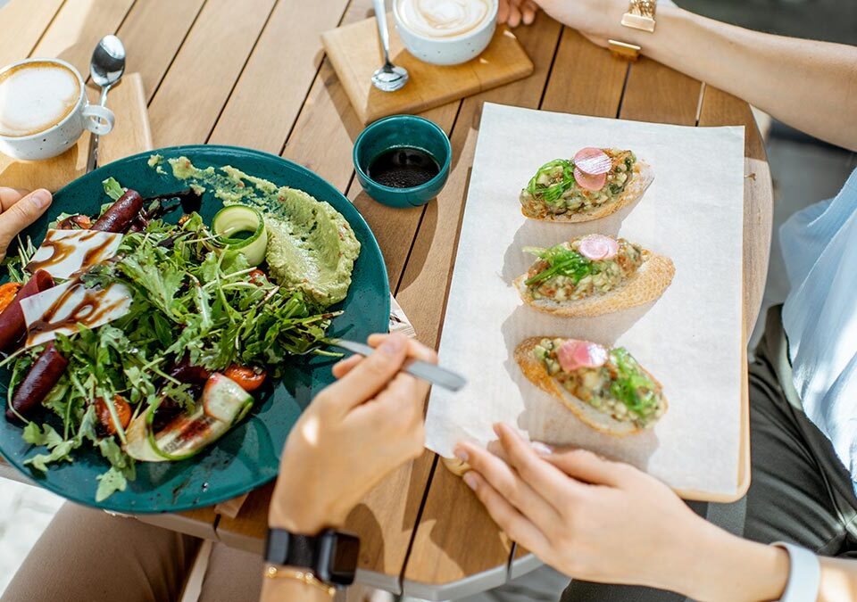 Duas pessoas sentadas comendo alimentos saudáveis