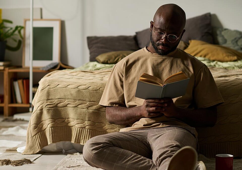 Homem lendo livro em seu momento pós trabalho