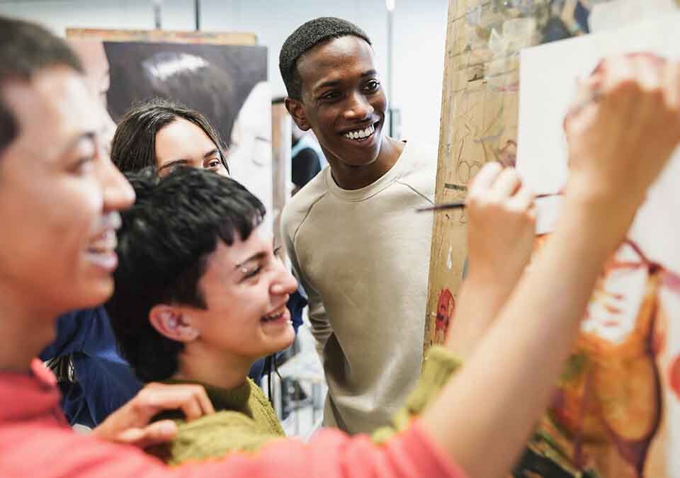 Estudantes multirraciais pintando dentro da sala de arte classe na universidade