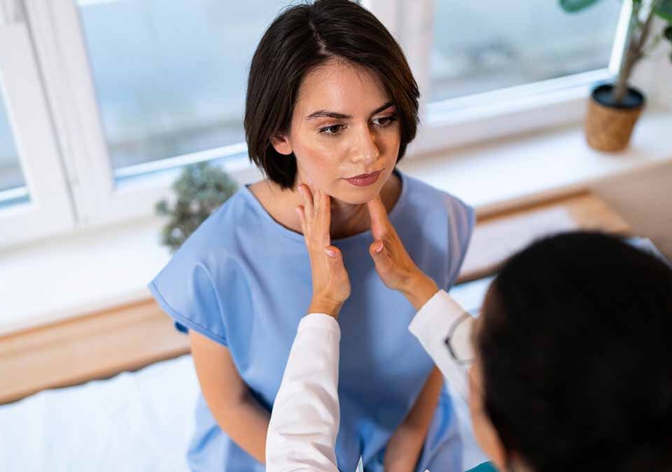Médica examina a glândula tireoide paciente feminina