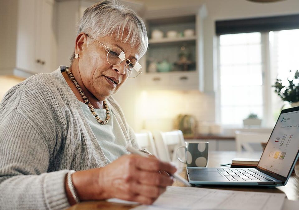 Senhora analisando suas finanças no notebook