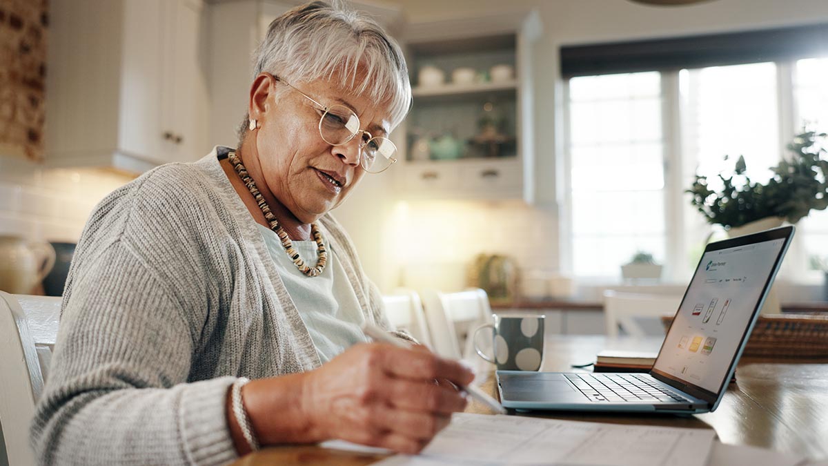 Senhora analisando suas finanças no notebook