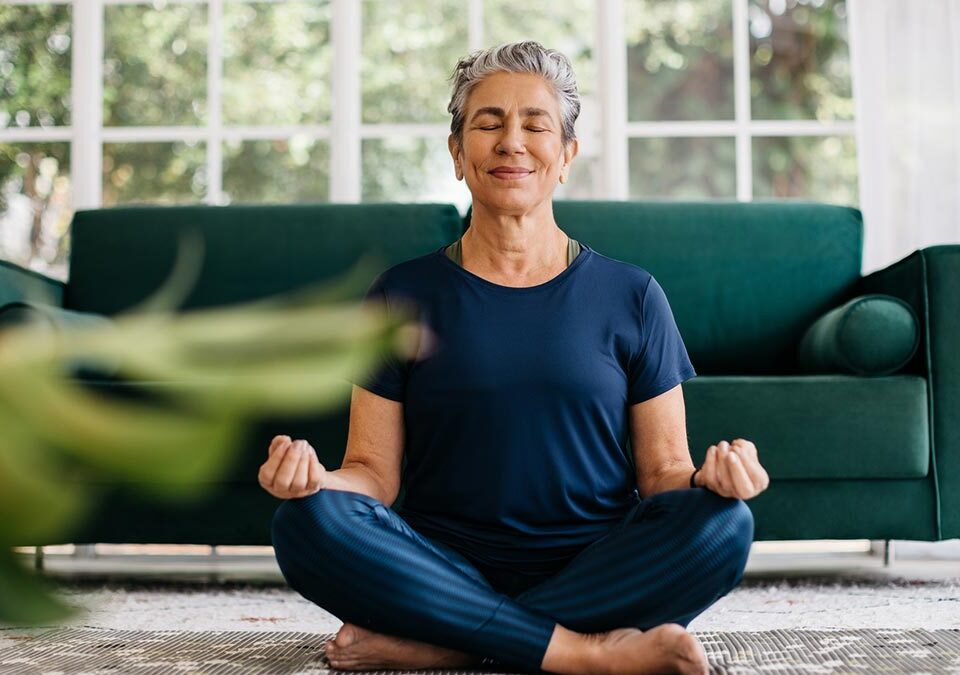 Mulher meditando no meio da sala