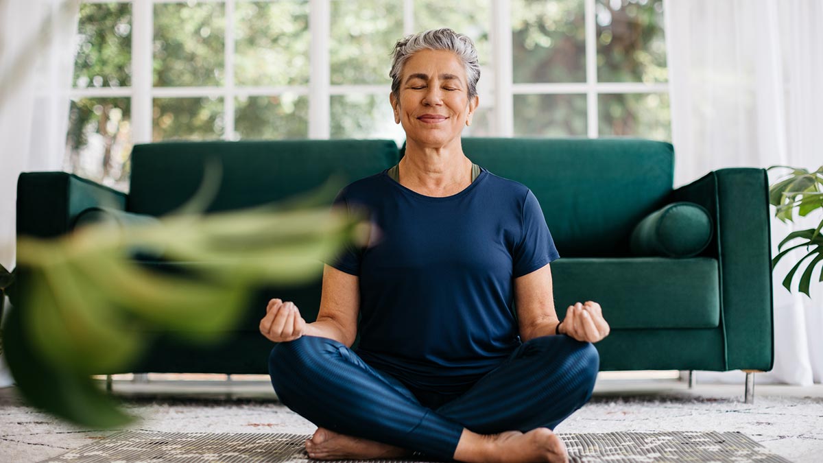 Mulher meditando no meio da sala